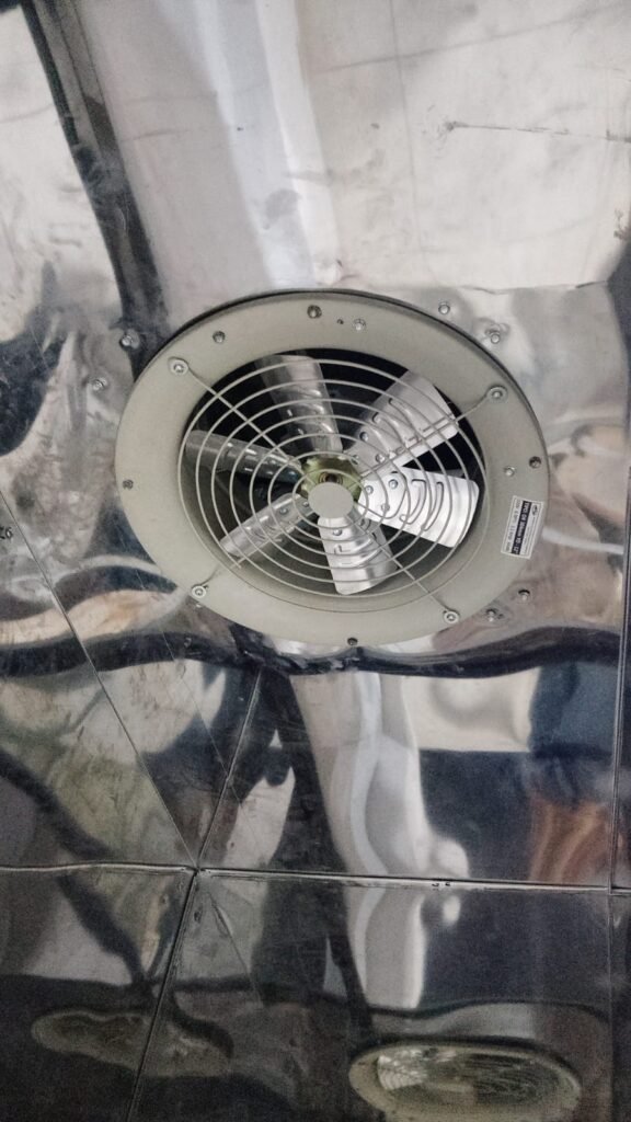Extractor axial industrial con rejilla instalado en una campana extractora industrial